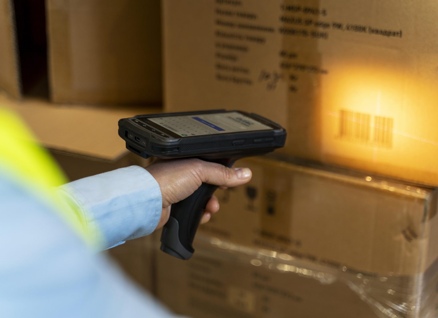 A man scanning a box label in a warehouse